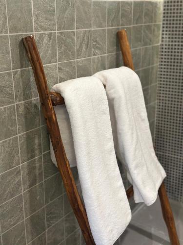 a towel rack with white towels on it in a bathroom at Arjuna Hill in Sumberbrantas