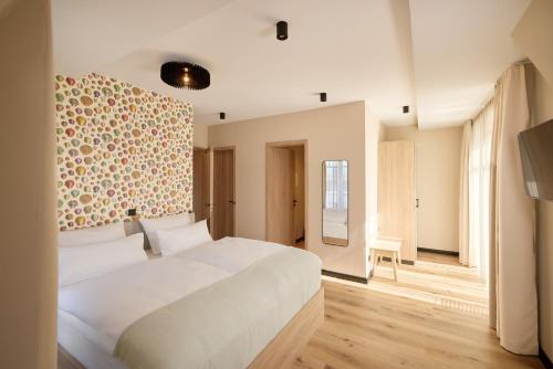 a bedroom with a white bed and a wall at Gezeiten Suites Büsum - Neueröffnung in Büsum