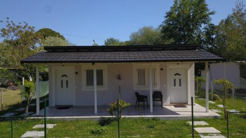 a small white house with a table and chairs at Villa Gersi in Divjakë