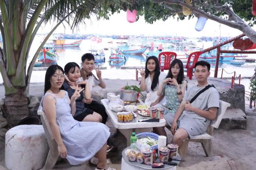 a group of people sitting around a table eating food at Hoa Bien Motel in Ly Son