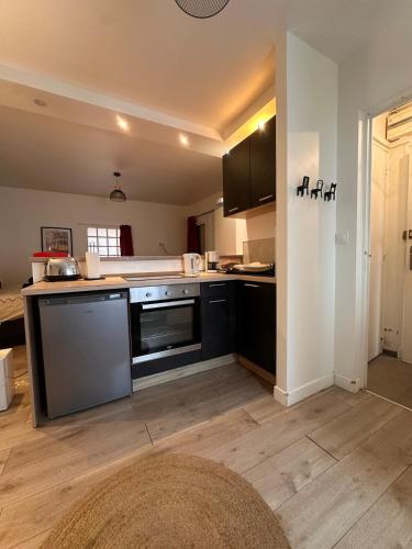 a kitchen with black appliances and a wooden floor at L'Essentiel de Paray in Paray-le-Monial