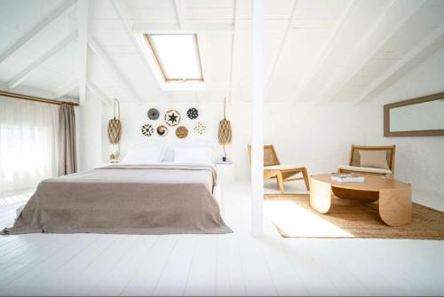a white bedroom with a bed and a table at Kurabiye Hotel in Alaçatı