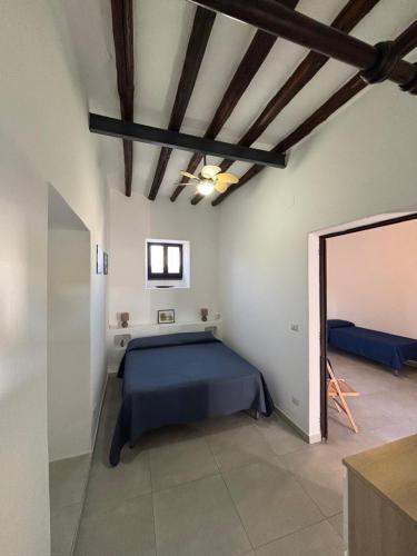 a bedroom with a blue bed and a mirror at Casa Cristian Stromboli in Stromboli
