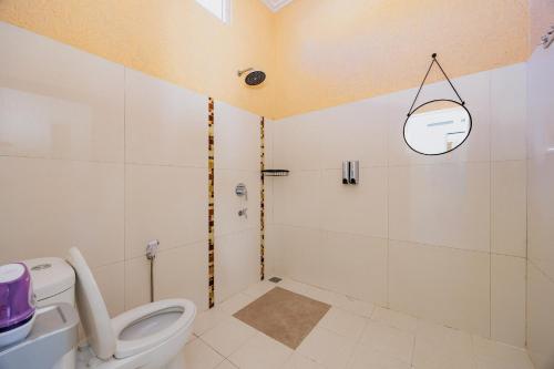 a bathroom with a toilet and a shower at The Lavana Signature Villa Herrera Puncak in Puncak