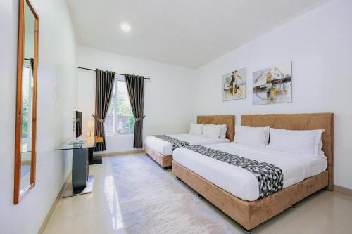a bedroom with two beds and a television in it at The Lavana Signature Villa Herrera Puncak in Puncak