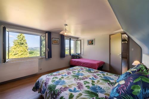 a bedroom with a bed and a large window at Gîte Les Sapins Douglas in Sansac-Veinazés