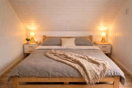 a bedroom with a large bed with a blanket on it at Mehrblick Kopice in Stepnica