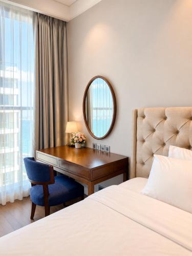 a hotel room with a desk and a bed and a mirror at Bow Luxury 3 in Danang