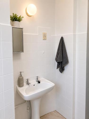 a white bathroom with a sink and a mirror at Scottburgh Peacehaven Holiday Flat 202 in Scottburgh