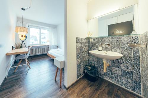 a bathroom with a sink and a mirror at Hostel by Hyve Basel in Basel
