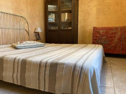 a bedroom with a bed with a striped blanket at Vautrain in Artignosc-sur-Verdon