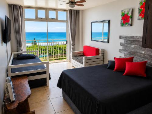 a bedroom with a bed and a view of the ocean at Scottburgh Peacehaven Holiday Flat 202 in Scottburgh