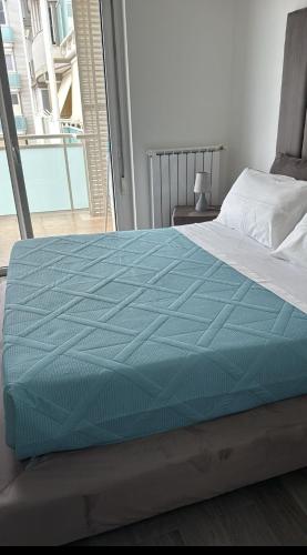 a bed with a blue comforter on top of it at Airport bari grey in Bari