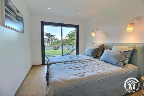 a bedroom with a large bed with a large window at Brise marine in Trébeurden