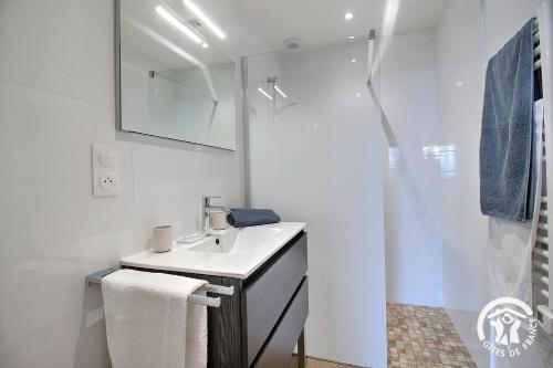 a white bathroom with a sink and a shower at Brise marine in Trébeurden