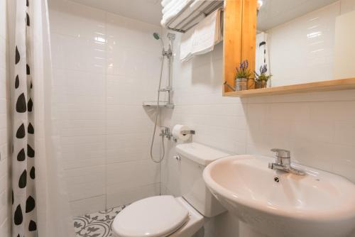 a white bathroom with a toilet and a sink at Neat House in Seoul