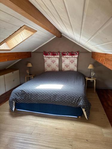 a bedroom with a large bed in a attic at Omazot au calme dans verdure in Aix-les-Bains