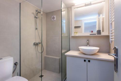 a bathroom with a shower with a sink and a toilet at Balaris Apartments in Kassiopi