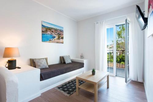 a living room with a bed and a balcony at Balaris Apartments in Kassiopi