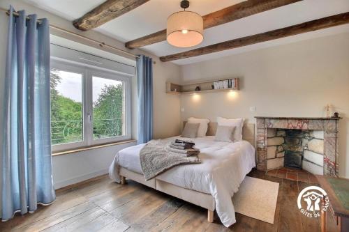 a bedroom with a bed and a fireplace at Le clos des sittelles in Theix