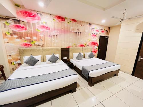 two beds in a room with flowers on the wall at Southern Stays in New Delhi