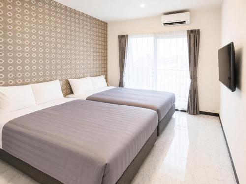 a hotel room with two beds and a window at MrKINJO in Air Resort in Hirara