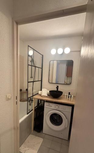 a bathroom with a washing machine and a sink at Studio cabine parking 4 pers plage à proximité in La Grande Motte