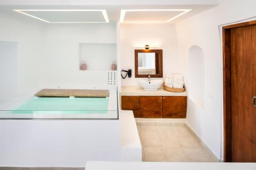 a bathroom with a sink and a mirror at Santorini Rooftop Hot Tub Suite with Panoramic Views in Akrotiri