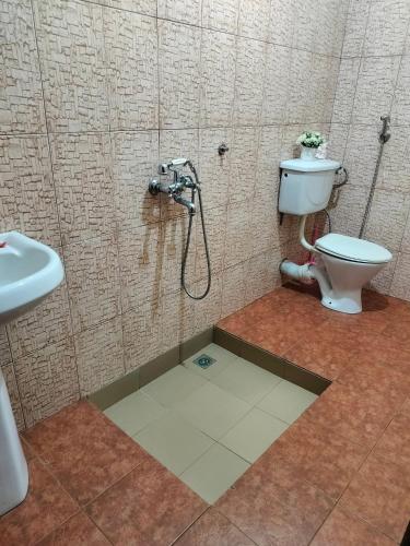 a bathroom with a shower and a toilet at Cross Roads BackPackers Entebbe in Entebbe