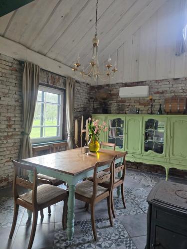 a dining room with a wooden table and chairs at Žemosios Panemunės dvaro sodininko namas in Žemoji Panemunė