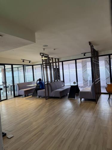a person sitting in a room with couches and windows at The Destination by Gidanka in Abuja