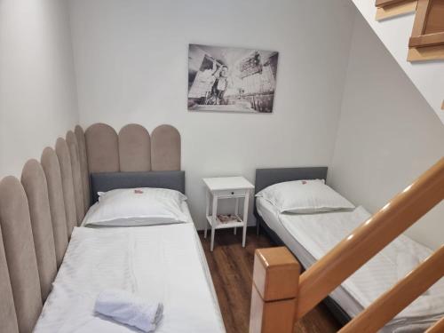 a small room with two beds and a staircase at Orzechowy Dom in Trzebnica