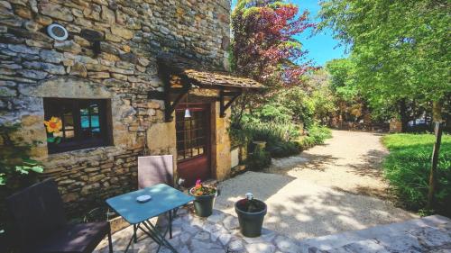 a stone house with a blue table and a door at Bonfarto Locations in Urval