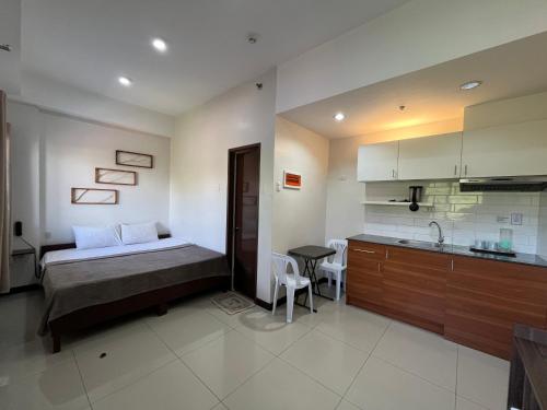 a bedroom with a bed and a kitchen in it at Cornerstone Manor Inn in Cebu City