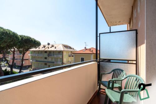 two chairs on a balcony with a view of a building at Hotiday Lavagna Lungomare in Lavagna