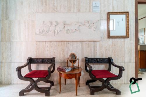 two chairs and a table in a room with a mirror at Hotiday Lavagna Lungomare in Lavagna
