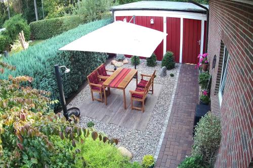 a table and chairs under an umbrella in a garden at "Haus Waldblick" in Bad Bramstedt
