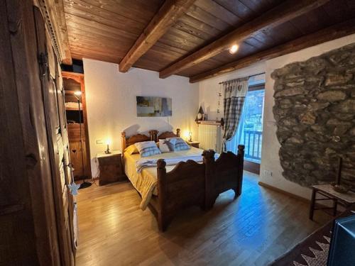 a bedroom with a bed and a stone wall at La Peiro Douco in Roure Turin