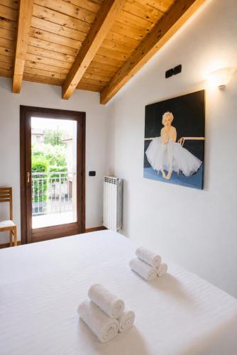 a bedroom with a white bed with towels on it at Carmel Self-Apartment in Castelnuovo del Garda