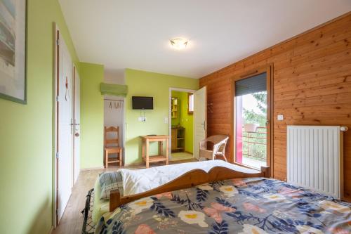 a bedroom with a bed in a room with green walls at Gite Nature Ressourcement-Vosges in Le Tholy