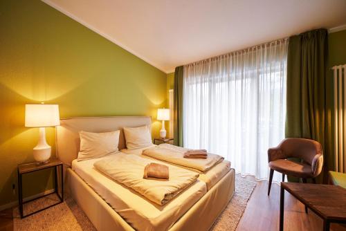 a hotel room with a bed and a chair at Ferienanlage Kirchzarten in Kirchzarten