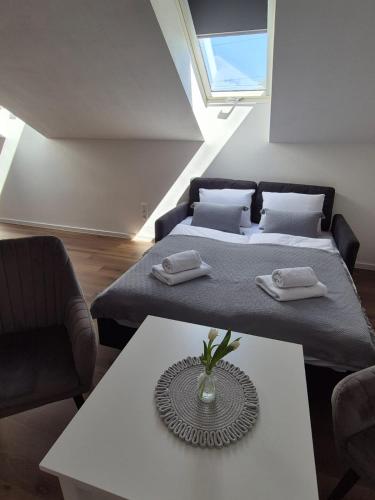 a living room with two beds and a table at Apartmán By One in Banská Štiavnica