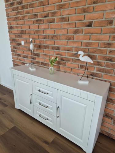 a white dresser against a brick wall at Apartmán By One in Banská Štiavnica