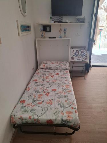 a bedroom with a bed with a floral bedspread at La Casetta dei Paceri in Syracuse