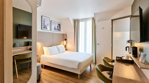 a hotel room with a white bed and a mirror at Campanile Prime - Paris 14 Maine Montparnasse in Paris