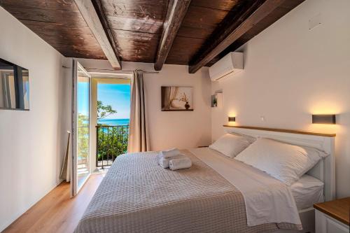 a bedroom with a bed with a view of the ocean at Angelina in Jakišnica