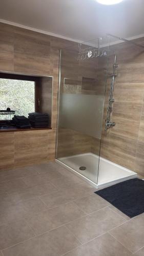 a shower with a glass door in a bathroom at Haus in Roth an der Our in Roth