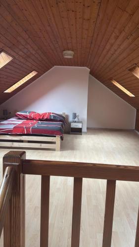 a bed in a room with a wooden ceiling at Haus in Roth an der Our in Roth