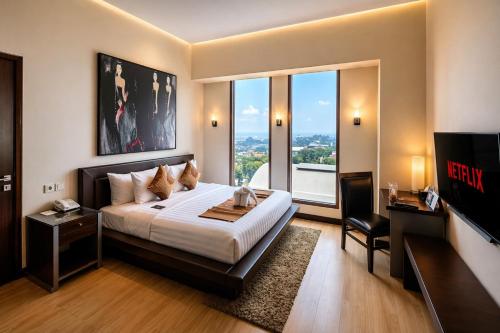 a bedroom with a bed and a large window at Grand Candi Hotel in Semarang