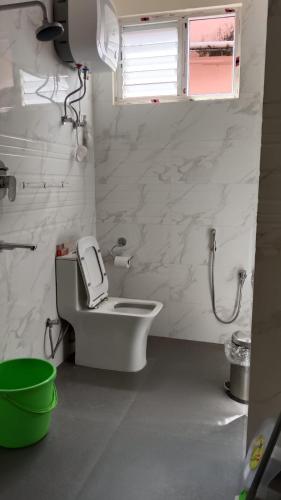 a white bathroom with a toilet and a window at The Bliss Hotel and Restaurant in Gangtok